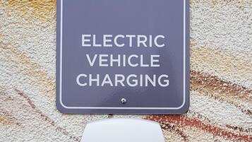 An electric vehicle charging station with a sign above it.