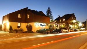 A hotel named "Angela" with a modern design, featuring a parking lot and multiple cars parked in front. - Hotel Restaurant Angelo (Saarbrücken)