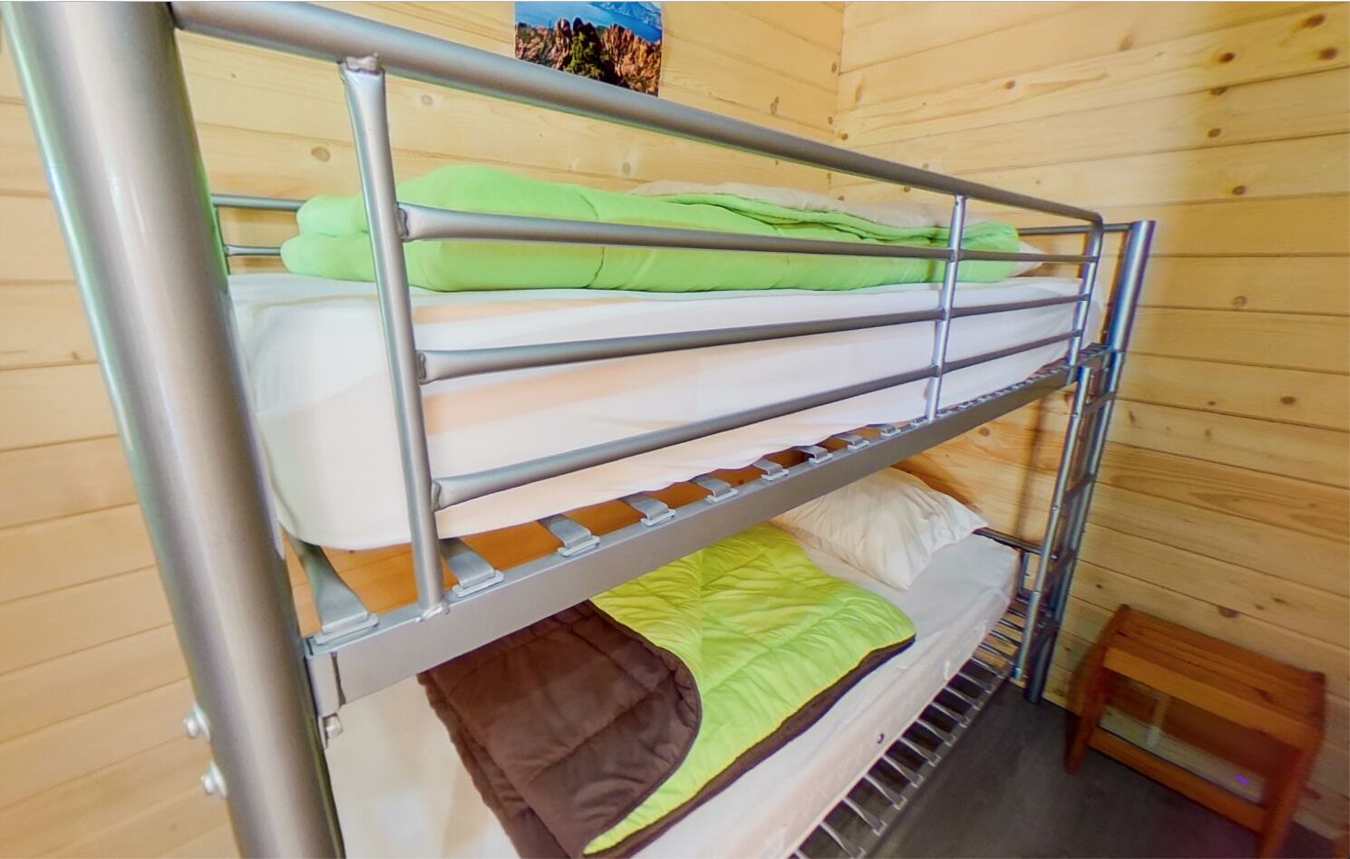 A bunk bed with three levels, each with a mattress and pillows.