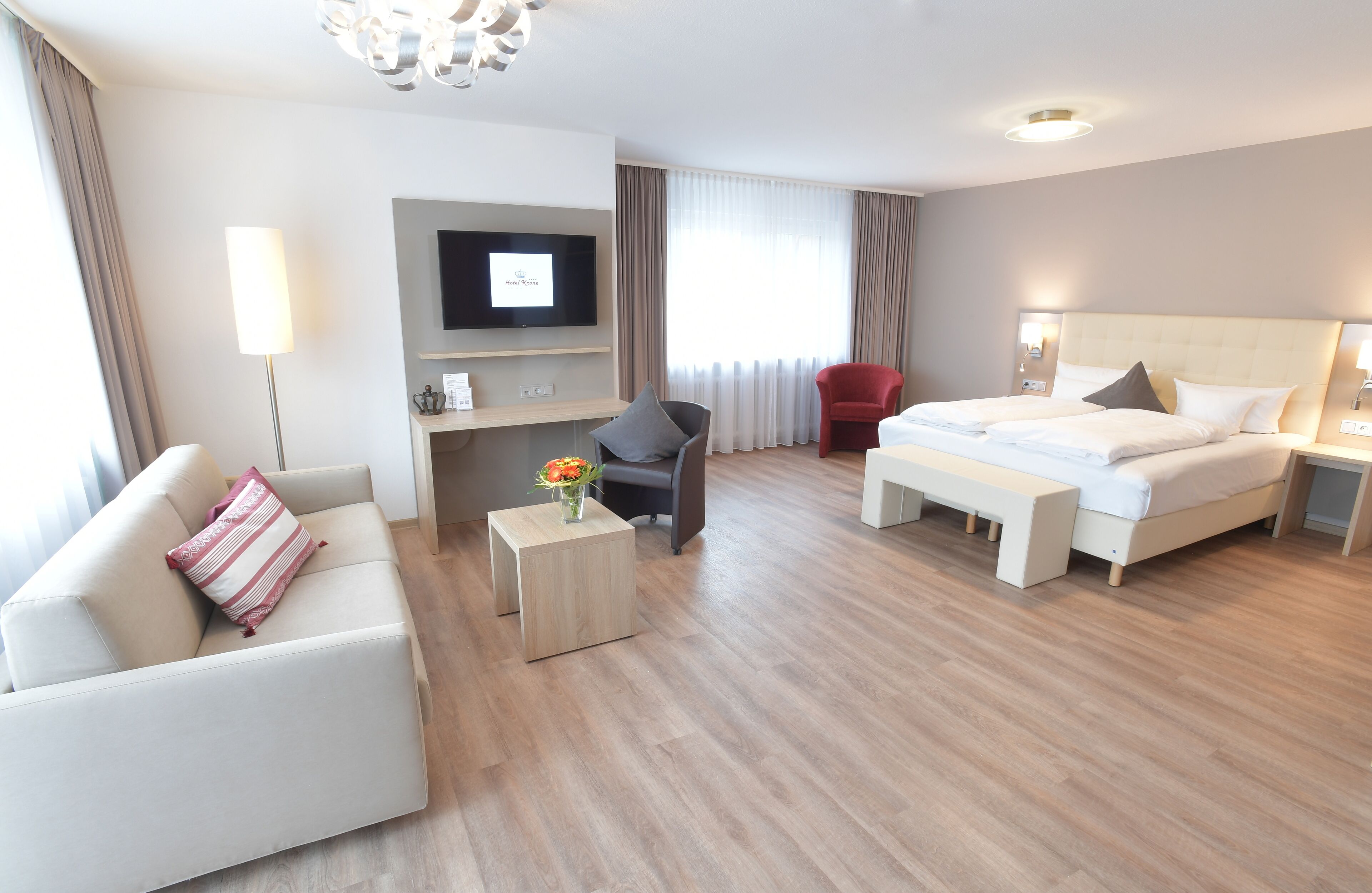 Une chambre d’hôtel équipée d’un lit, d’un canapé, d’un bureau, d’une télévision et d’une chaise.