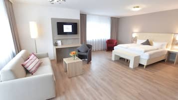 Une chambre d’hôtel équipée d’un lit, d’un canapé, d’un bureau, d’une télévision et d’une chaise.