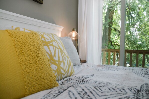 Un dormitorio con cama, mesita de noche y lámpara.
