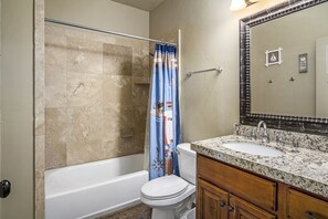 A bathroom with a bathtub, toilet, and sink.