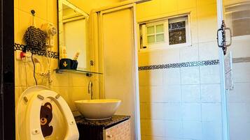 Et badeværelse med toilet, vask og bruser.
