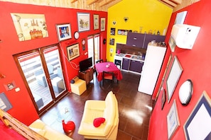 A compact living space with a dining area, kitchen, and a balcony with a view.