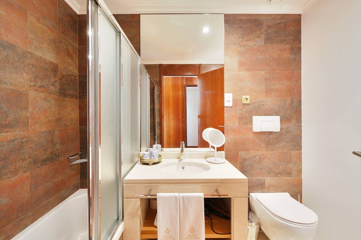 bathtub, hair dryer, towels, soap