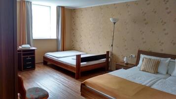 A room with a bed, a desk, a chair, a lamp, and a window.