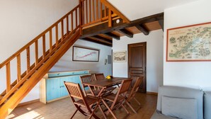 A dining area with a wooden staircase, a blue cabinet, and a map on the wall. - Cosy apartment for 4 people with WIFI, A/C, TV and terrace (Cavalaire-sur-mer)