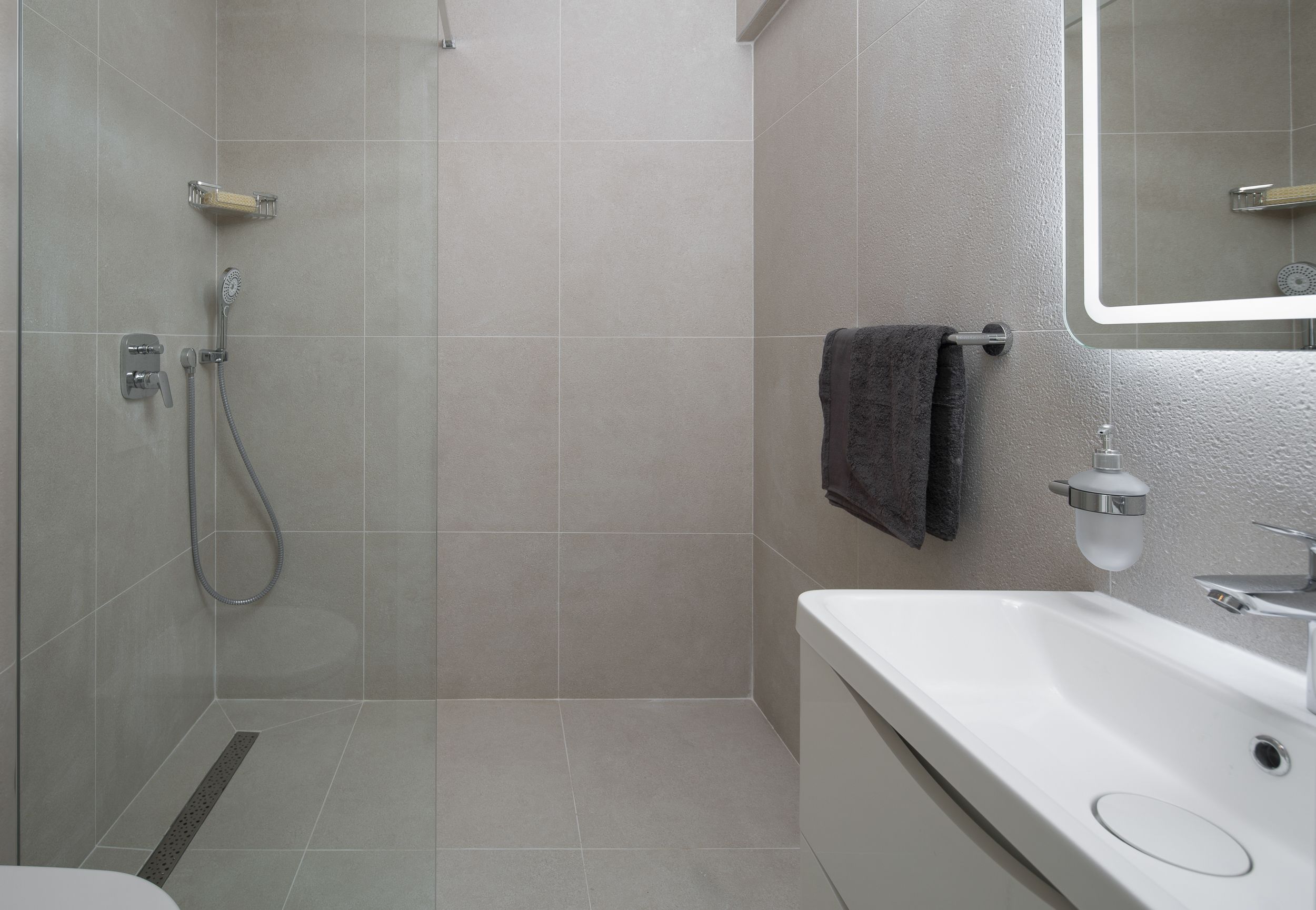 Un bagno moderno con doccia, WC e lavandino.