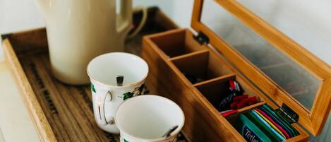 A wooden tray with two white mugs and a beige teapot.