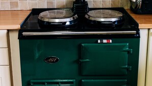 Una estufa vintage verde con horno integrado y extractor de humos.