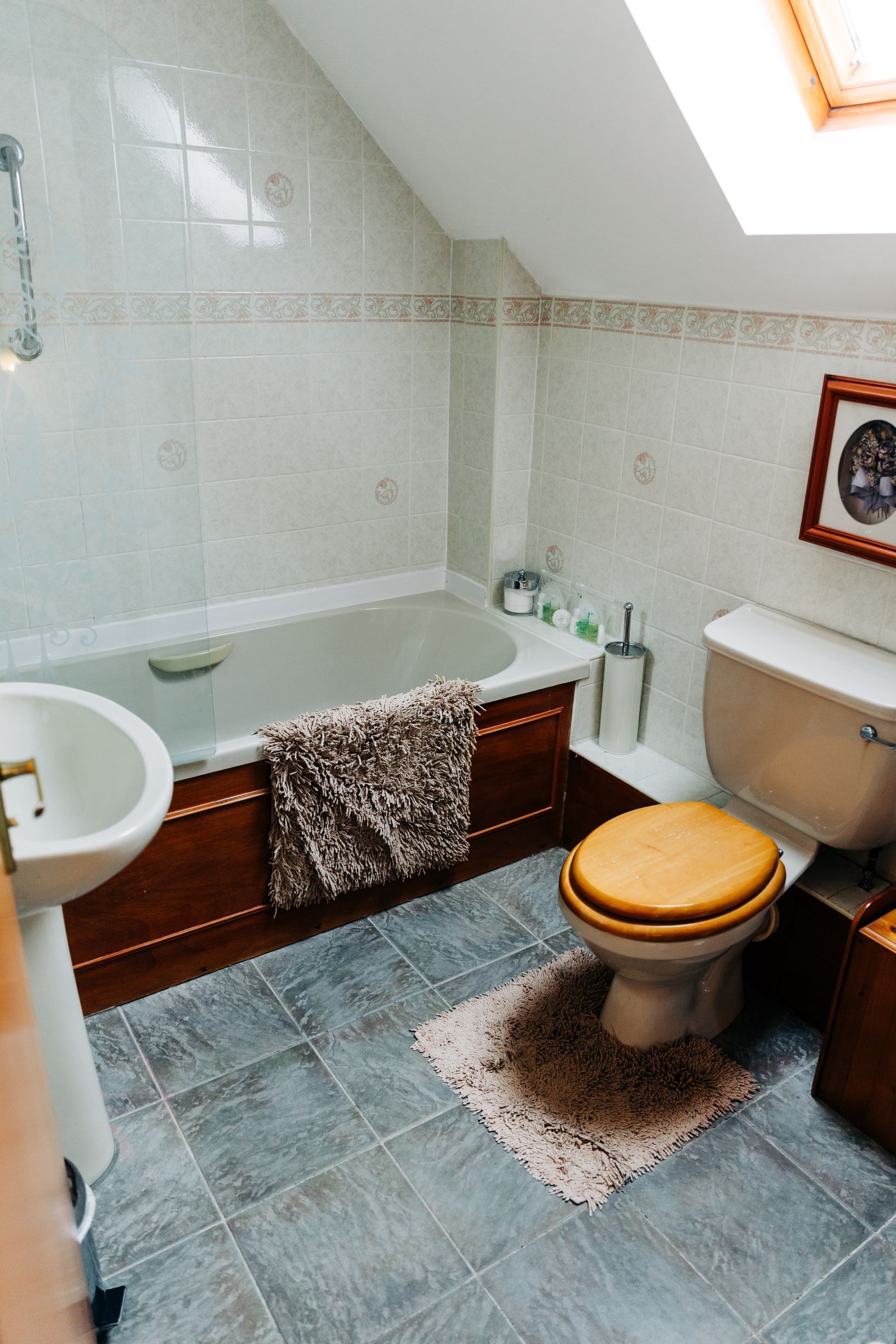 Ein Badezimmer mit Badewanne, Toilette, Waschbecken und einem Oberlicht.