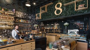 A coffee shop interior with shelves of coffee beans, jars of condiments, and a large number '8' sign. - The Stay by Aston (Plovdiv)