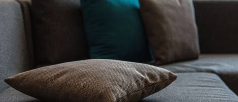 A sofa with a textured fabric and a single cushion.
