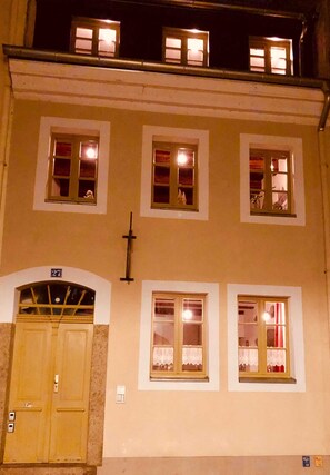 A building with multiple windows, a door, and a cross on the wall. - Landeskrone loft maisonette - Altstadthaus / Ferienwohnungen Görlitz (Görlitz)