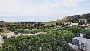 A coastal residential area with houses, a road, and a view of the sea. - Verde Mare (San Vito Lo Capo)