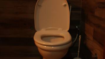 Een toilet in een kamer met houten lambrisering.