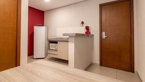 Una cocina compacta equipada con microondas, refrigerador y cafetera.