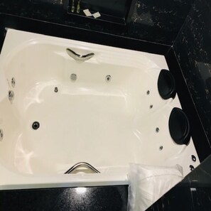 A white bathtub with two black faucets and a drain. - 103 Hotel & Flats (Palmas)