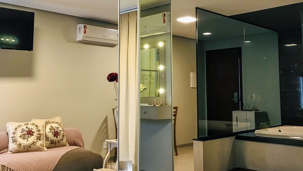 Un dormitorio moderno con cama, mesita de noche y un espejo grande.