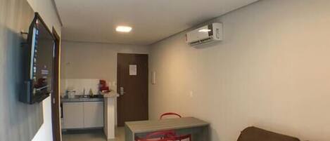 Un espacio habitable pequeño con kitchenette, comedor y sofá.