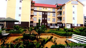 A multi-story residential building with balconies and a landscaped courtyard. - Ridge Apartments (Eldoret)