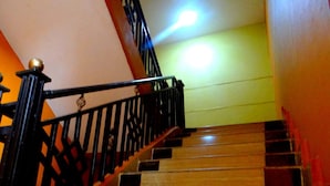A staircase with wooden steps and black railings. - Ridge Apartments (Eldoret)