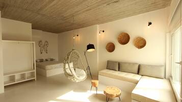 Un dormitorio moderno con una silla colgante, un sofá y una cama.