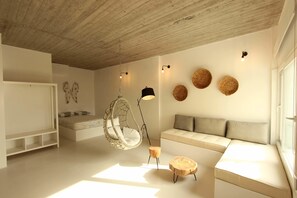 Un dormitorio moderno con una silla colgante, un sofá y una cama.