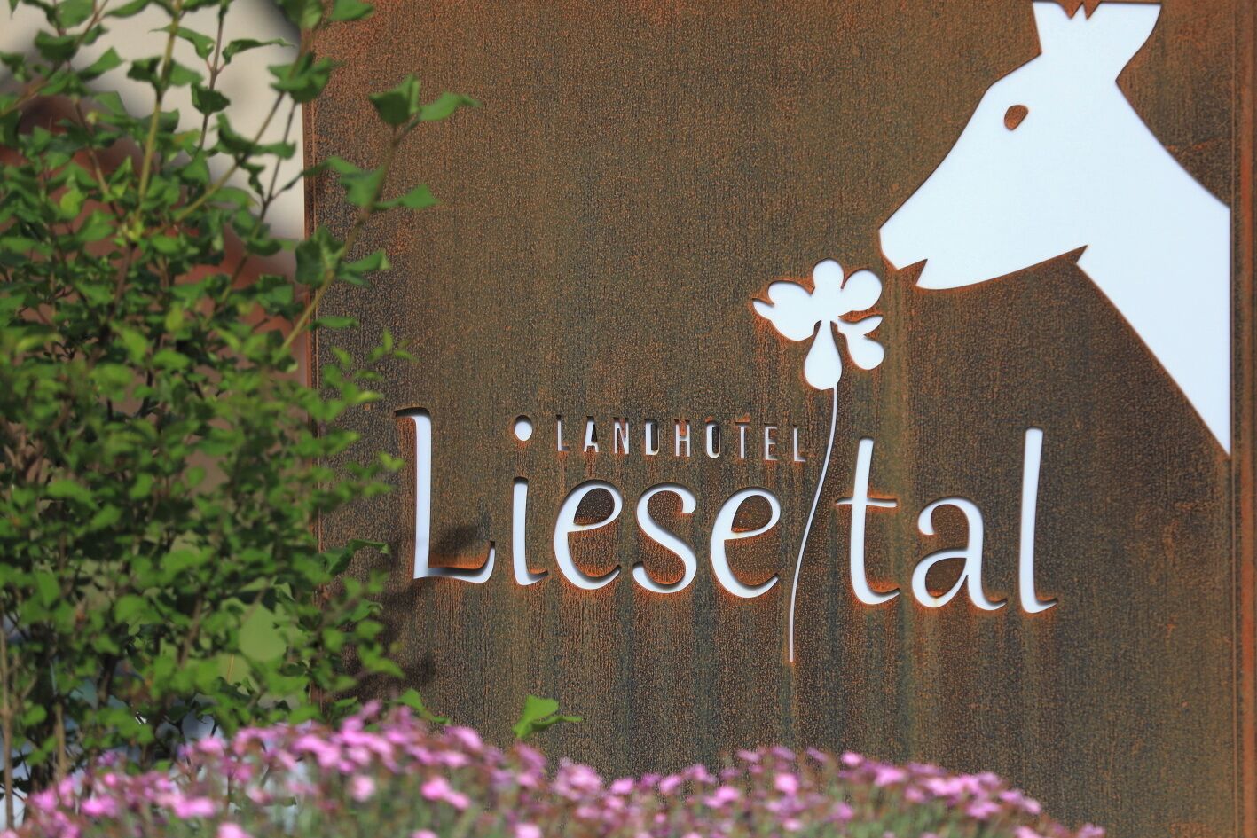Een bord met de tekst 'LANHOTEL Liesertal' en een witte silhouet van een hert.