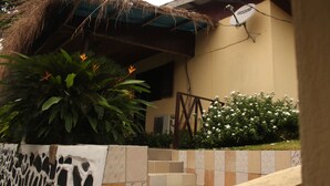 Un edificio con fachada de tejas, una antena parabólica y una escalera que lleva a la entrada.