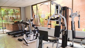 Una palestra con tapis roulant, cyclette e macchinari per l'allenamento con i pesi.