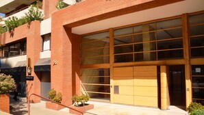 Un edificio moderno con un'ampia vetrata d'ingresso, pareti in mattoni e piccoli fiorieri.