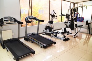 A gym with treadmills, an elliptical, and weight machines.