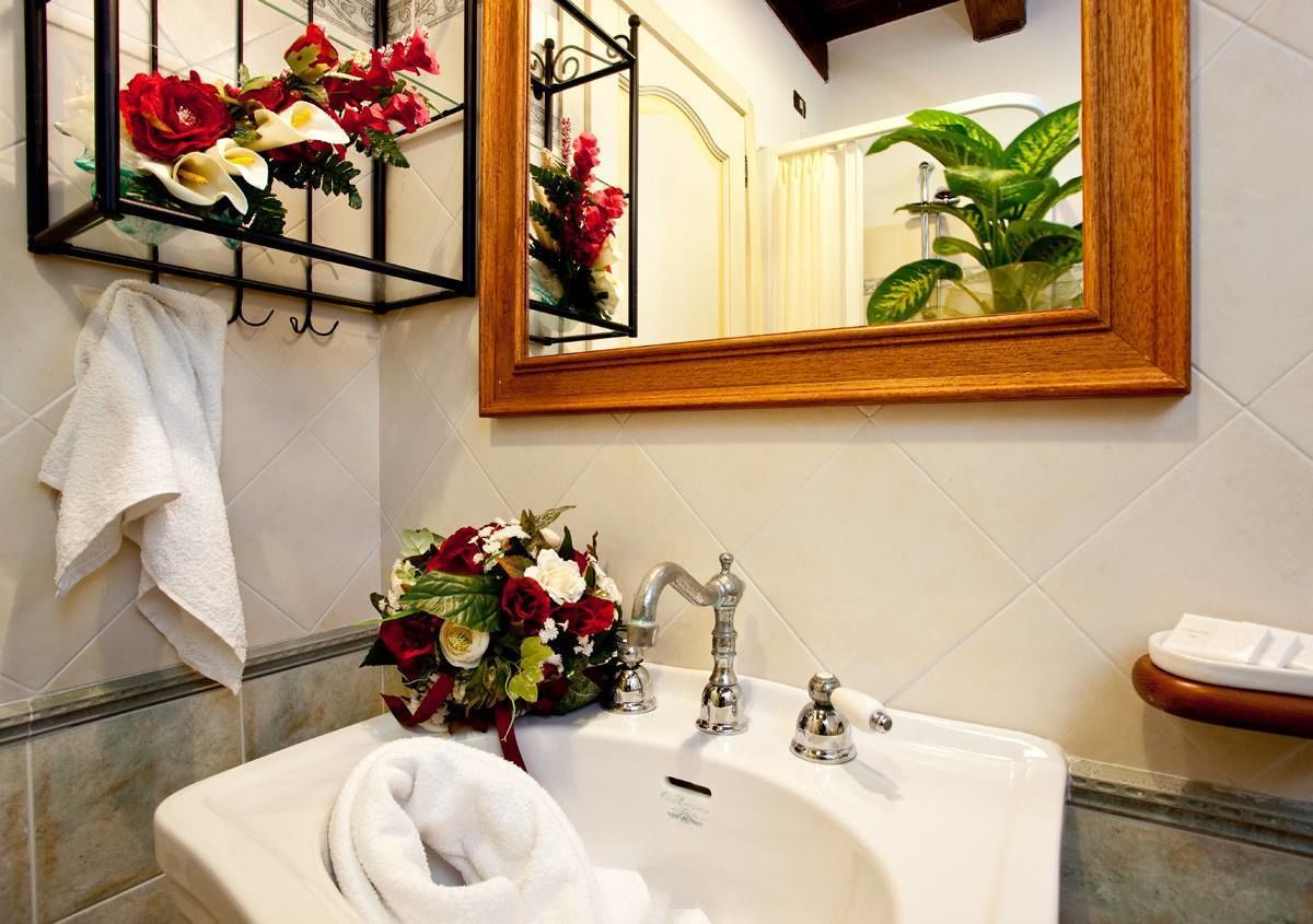 Un baño con un lavabo blanco, un espejo y un perchero para toallas.