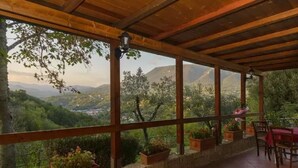 Un espacio de estar al aire libre cubierto con vistas a un paisaje montañoso.