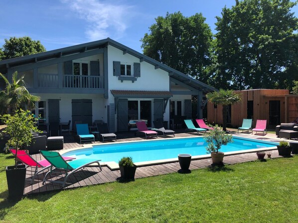Piscine extérieure en saison, parasols, chaises longues
