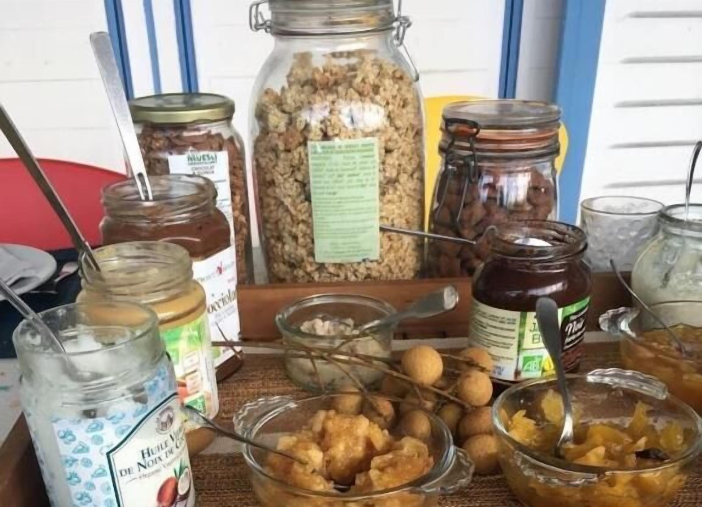 Una mesa con diversos alimentos y frascos, incluyendo frutos secos, miel y otros productos conservados.