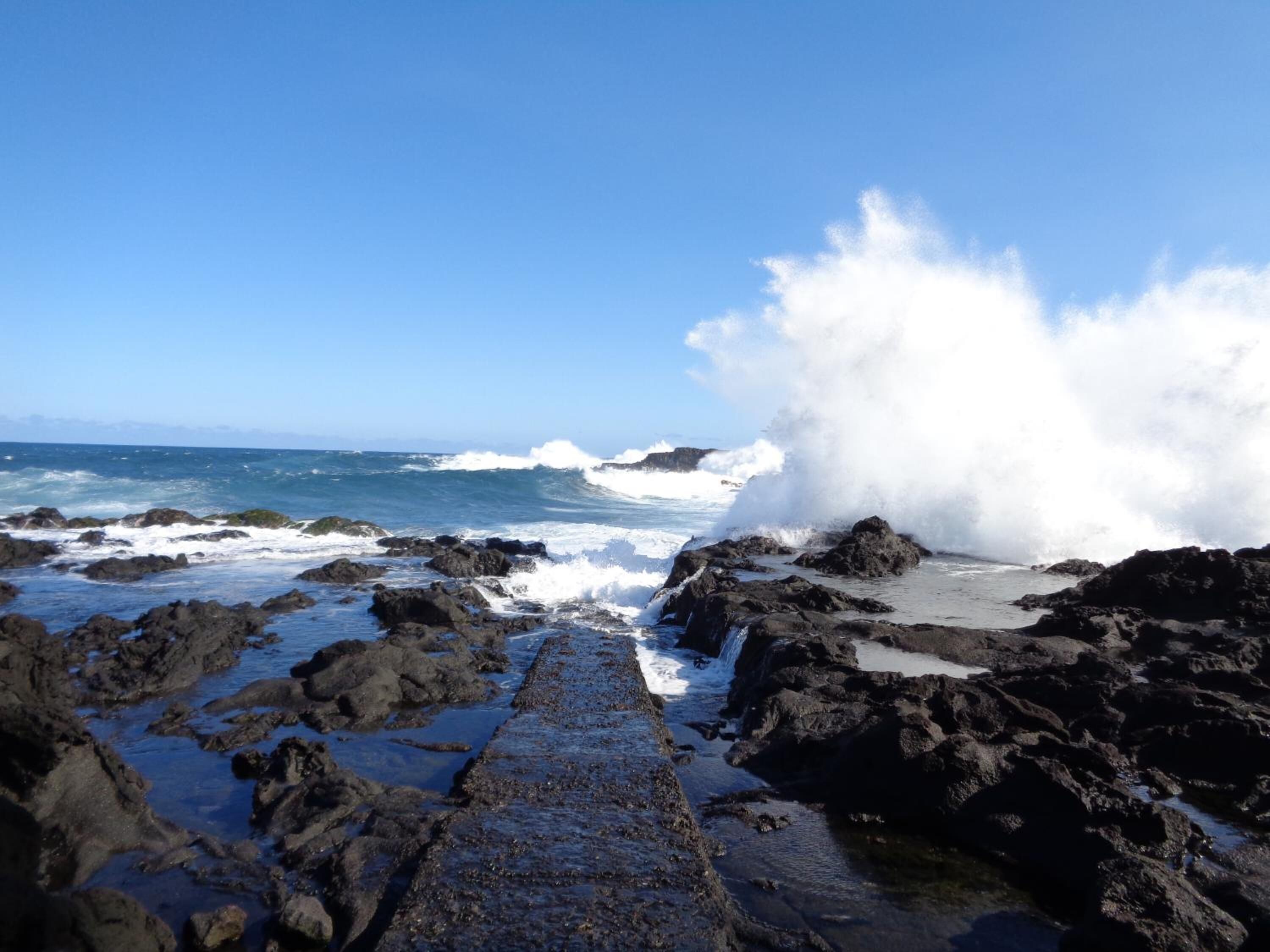 Una costa rocciosa con onde che si infrangono sulle rocce.