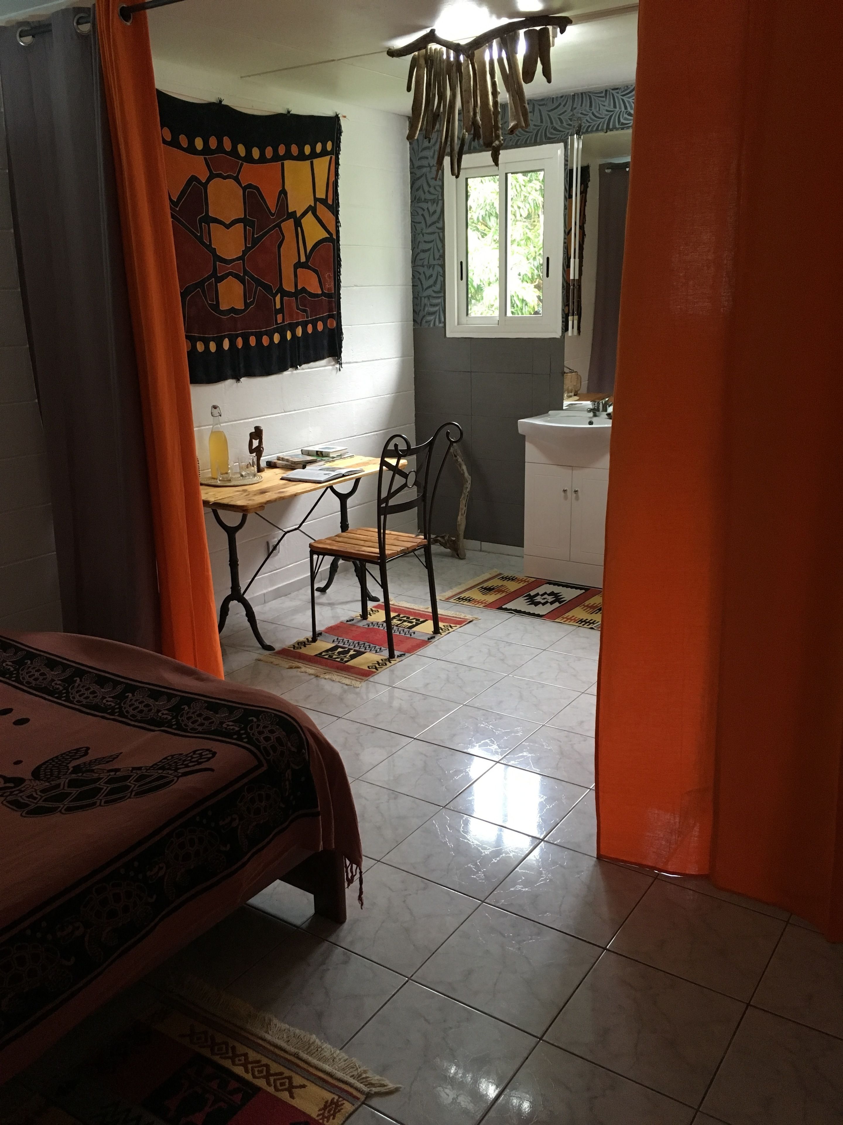 A bedroom with a bed, a desk, a chair, and a window.