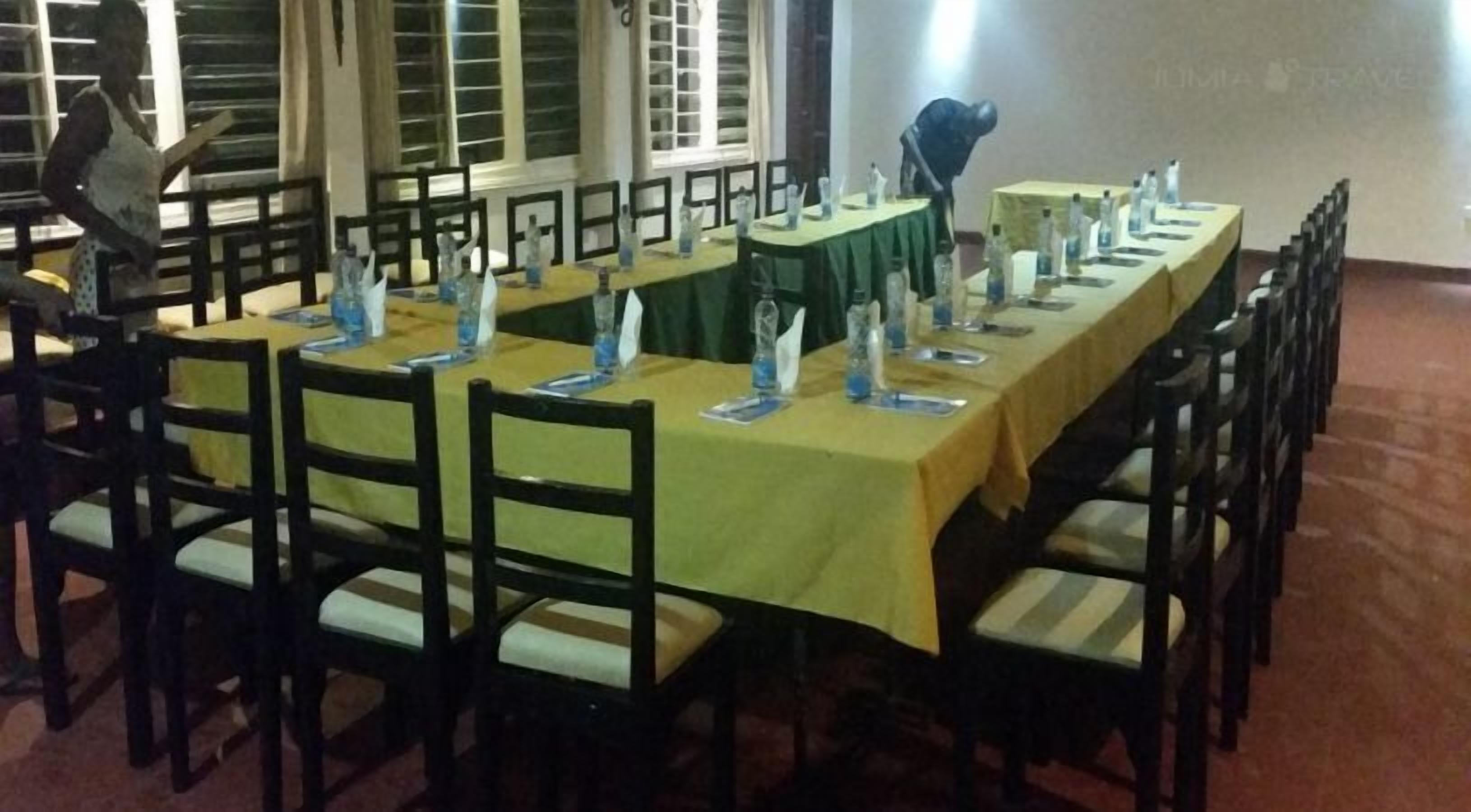 A conference room with long tables, chairs, and water bottles.
