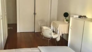 A bedroom with a bed, a chair, a small table, and a wardrobe. - Cerviño y Bulnes 2 (Buenos Aires)