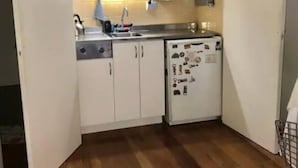 A compact kitchen with white cabinets, a microwave, a sink, and a dishwasher. - Cerviño y Bulnes 2 (Buenos Aires)