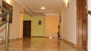 A hallway with a tiled floor, a staircase, and a door on the right. - Maison D Hote Villy (Ouagadougou)