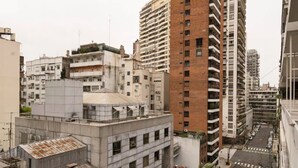 A high-rise building with multiple floors, a mix of residential and commercial spaces, and a street with parked cars. - Cerviño y Bulnes 3 (Buenos Aires)