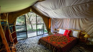Una habitación con carpa, una cama, una silla y vistas al exterior.