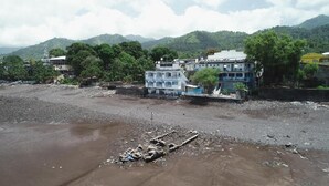 A riverbank with buildings and trees in the background. - Océanis Hotel (Mutsamudu)
