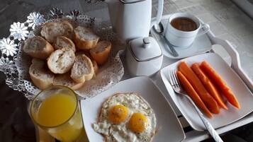 A breakfast tray with toast, eggs, carrots, and a cup of coffee.
