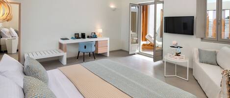 A modern hotel room with a bed, desk, and seating area.