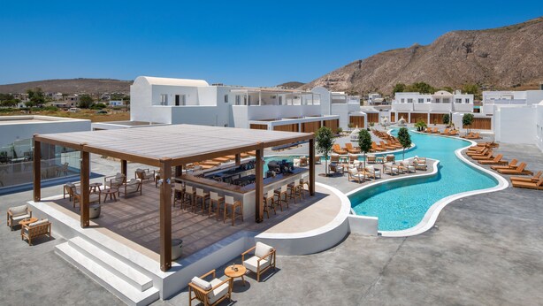 A resort with a pool, outdoor seating, and a mountainous backdrop. - Meltemi Blu - Adults Only (Santorini)
